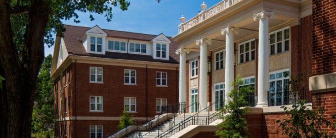 photo of building, day, blue sky, with person approaching staircase