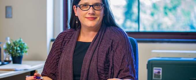 photo of woman in office with book and pen