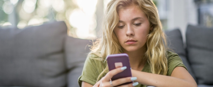 Photo of woman seated looking into cell phone