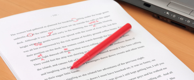 photo of paper with text, red pen, and laptop