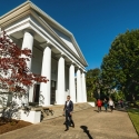 photo of people walking on sidewalk near classical building 