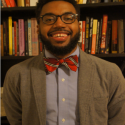 Photo of man in front of bookshelves