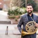 portrait of man holding French horn