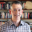 photo of man with books in background